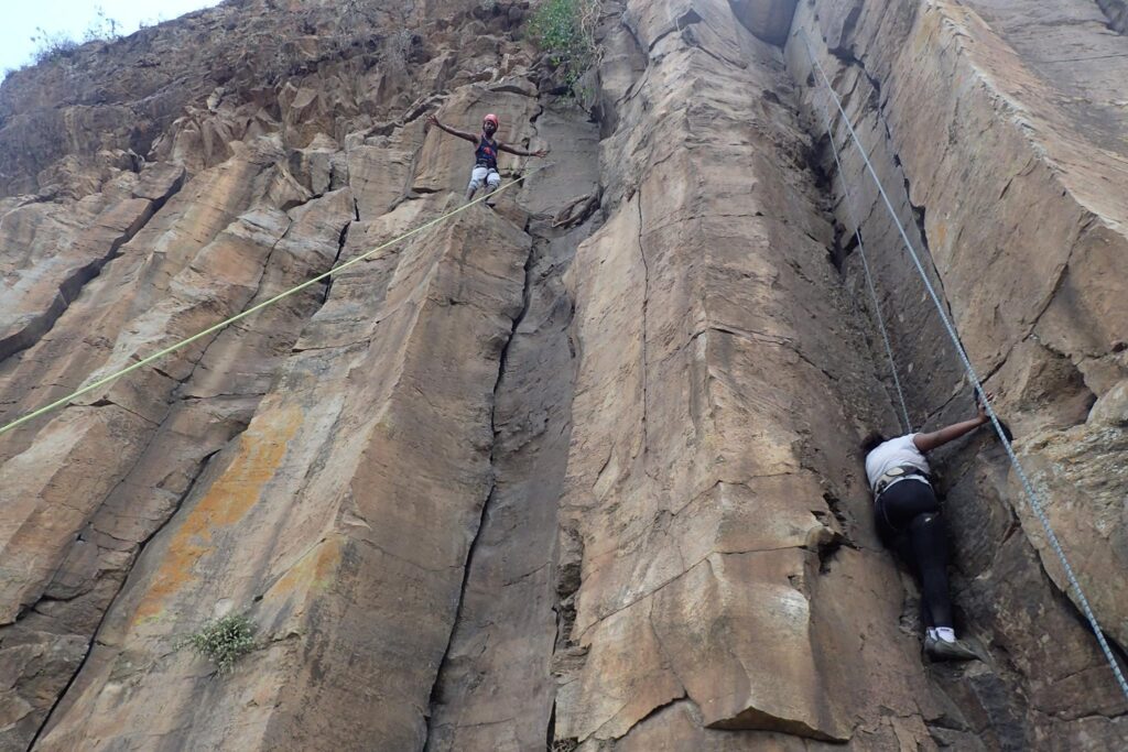 Rock climbers scaling the vertical volcanic routes of the Fischer’s Cliffs at Hell’s Gate National Park near Naivasha, Kenya — Guided by Bush Walker Adventures.